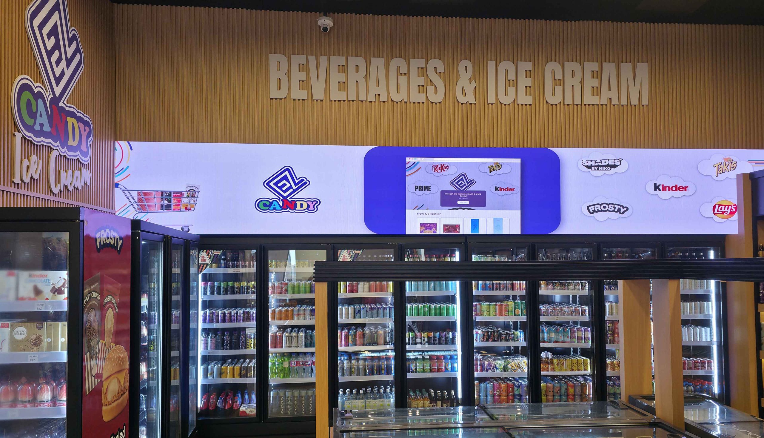 Ultra-wide indoor LED display above beverage refrigerators at EZ Candy Shop Dubai